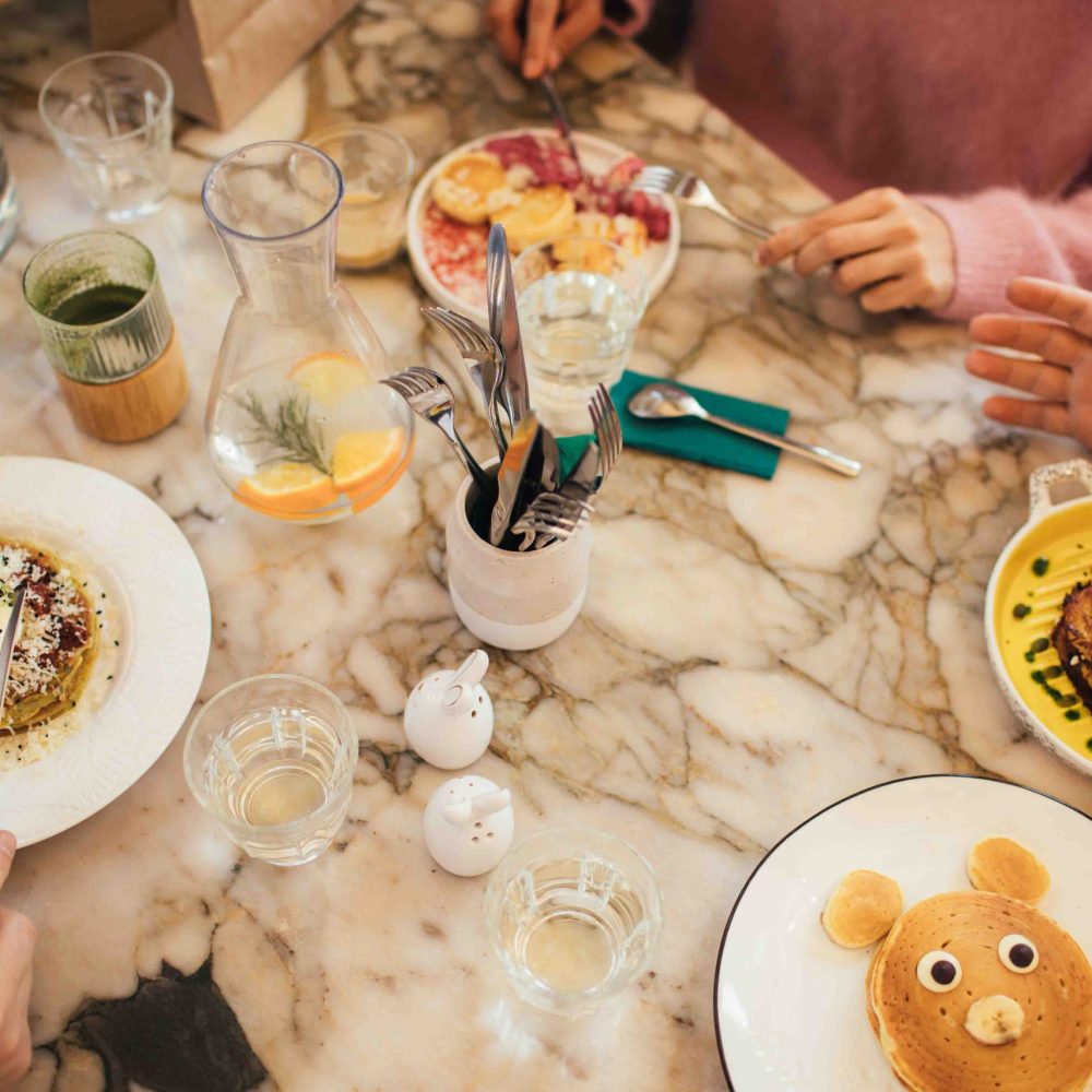 Group of millennial friends having breakfast together in a coffe Group of millennial friends having breakfast together in a cozy coffeeshop.