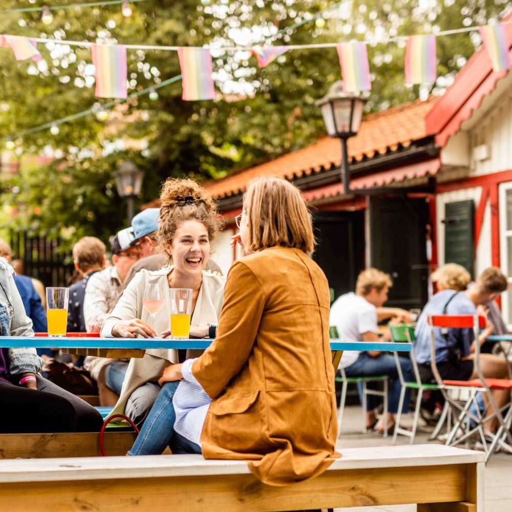 Young female friends relaxing in beer garden Young female friends relaxing in beer garden